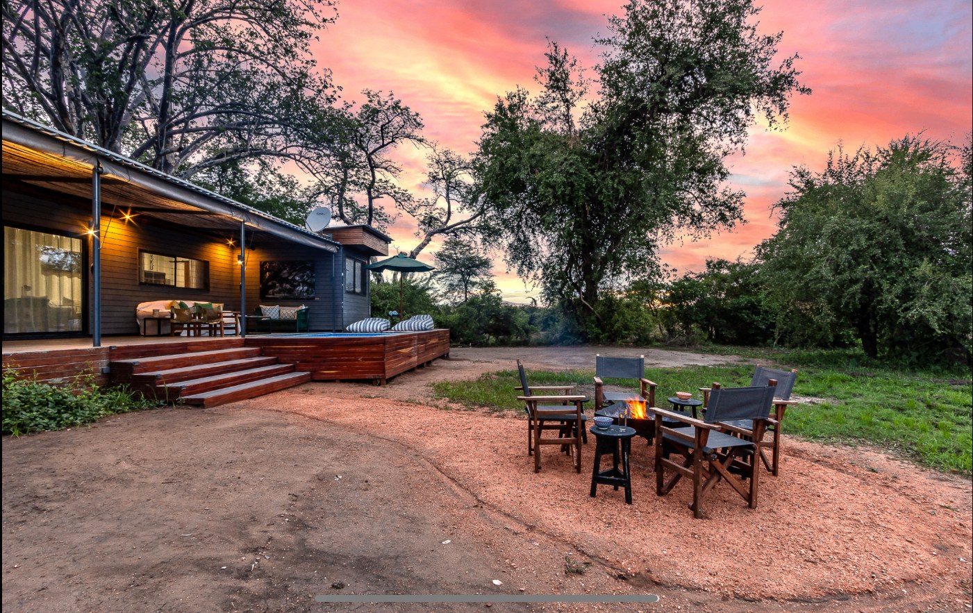 The Bush Box veranda and firepit at sunset with pink and orange skies